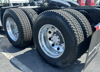 Freightliner Cascadia 126 truck rear wheel assembly showing dual rear axles and chrome rims.