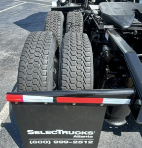 Rear view of a Freightliner Cascadia tractor showing tandem rear axles and dual tires with a SelectTrucks Atlanta logo plate.