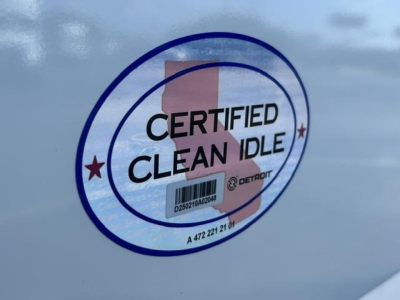 Truck side showing Certified Clean Idle badge with barcode sticker on door and reflection