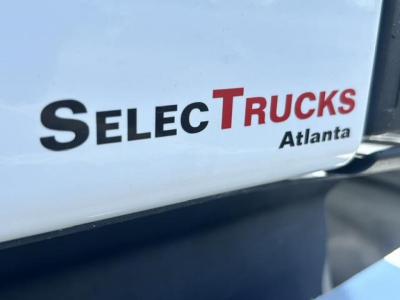 SelecTrucks Atlanta badge on Freightliner Cascadia truck body showing dealership logo.