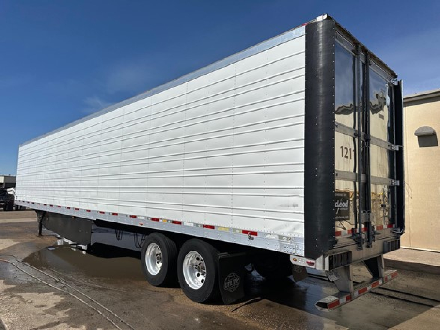 Utility 3000R trailer side and rear showing aluminum side panels and dual rear doors.