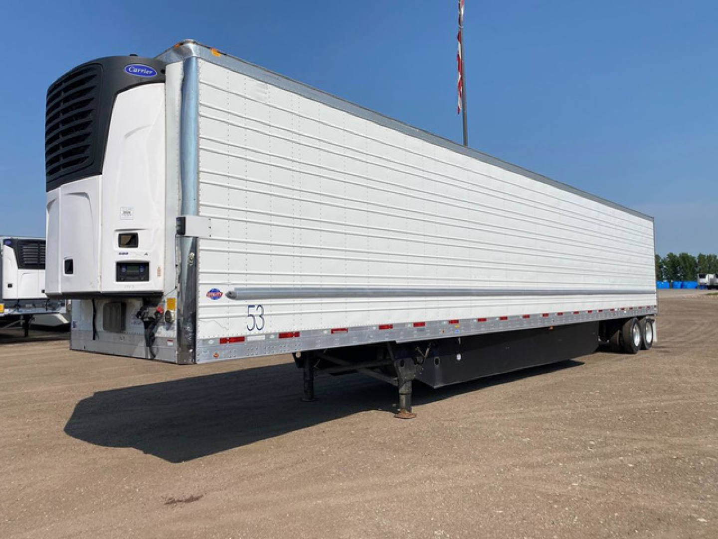 Refrigerated trailer with side profile, Thermo King unit at front, white corrugated sides, dual rear axles, stock number U91129 visible.