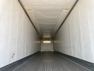 Interior of a 2021 Utility Reefer trailer cargo area showing clean white walls, ribbed floor, and narrow entry at far end.