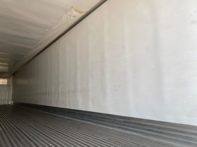 Trailer interior showing aluminum side walls and ribbed floor of a refrigerated trailer.