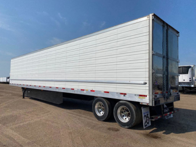 Utility refrigerated trailer in side view showing aluminum walls, tandem axles, and rear doors with metal frame.