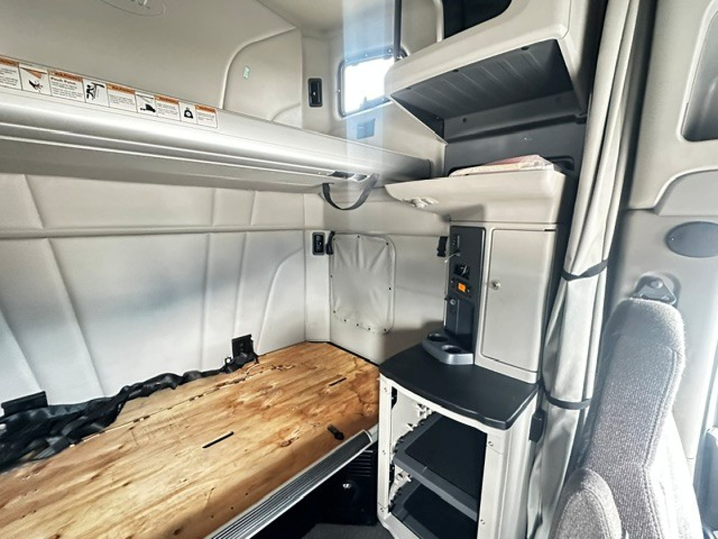 Peterbilt 579 cab interior showing sleeper area and control console with shelves and storage compartments.