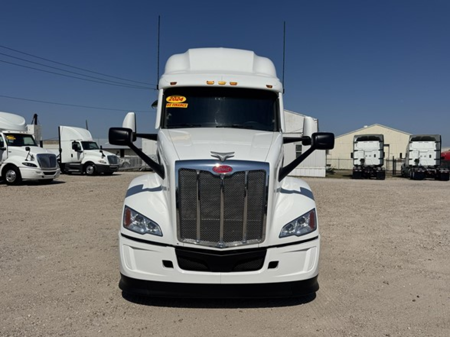 Peterbilt 579 front view showing grille, headlights, and large bumper with white paint and black accents.
