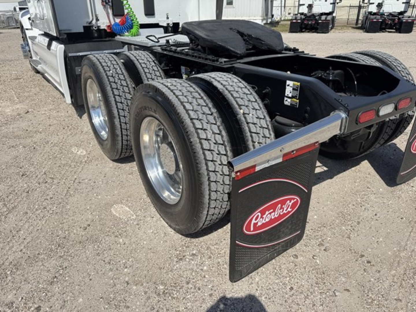 Peterbilt 579 tractor rear view showing dual rear axles and mudflap with Peterbilt logo