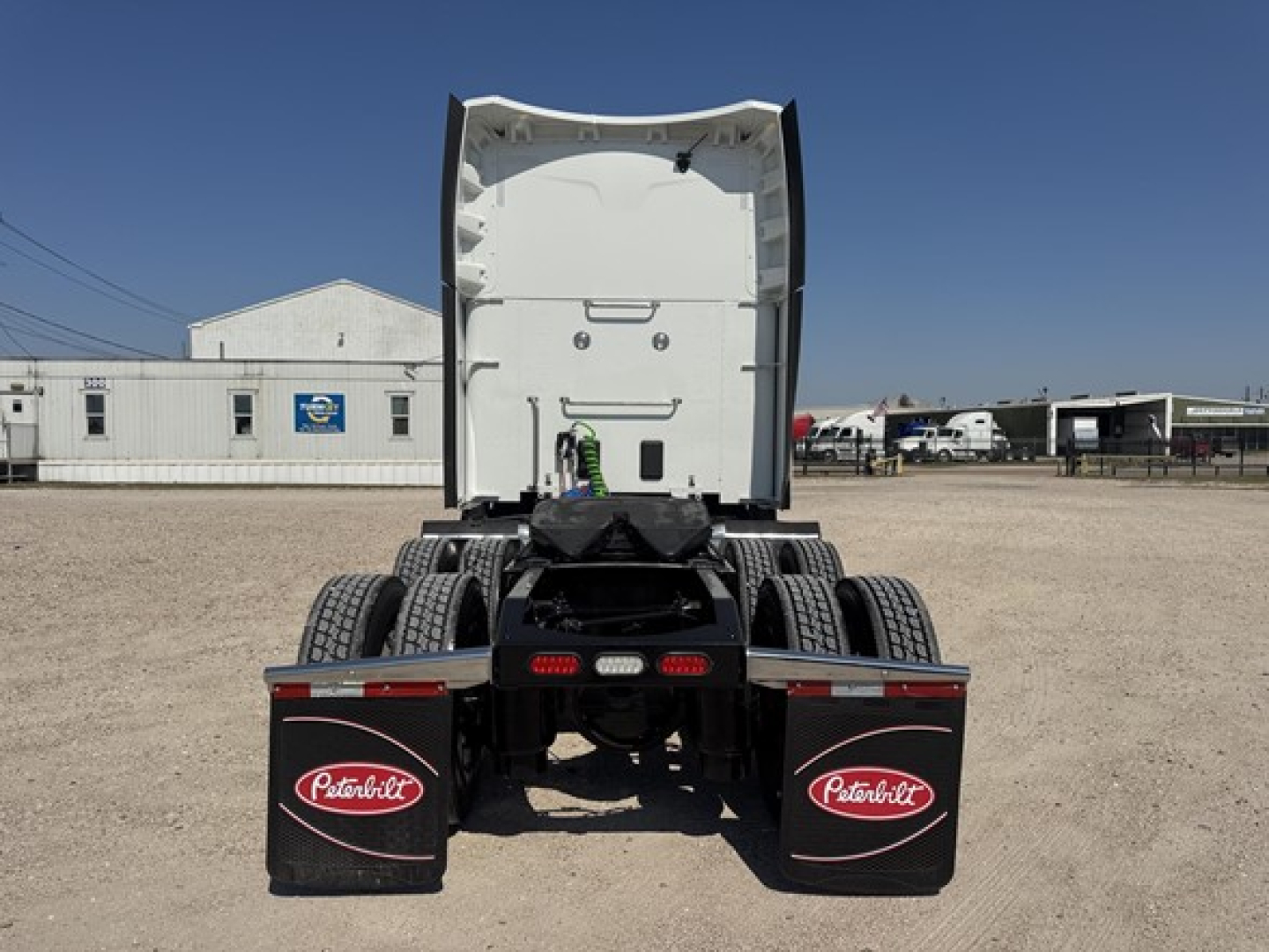Peterbilt 579 tractor rear view showing sleeper cab and dual rear axles with mud flaps