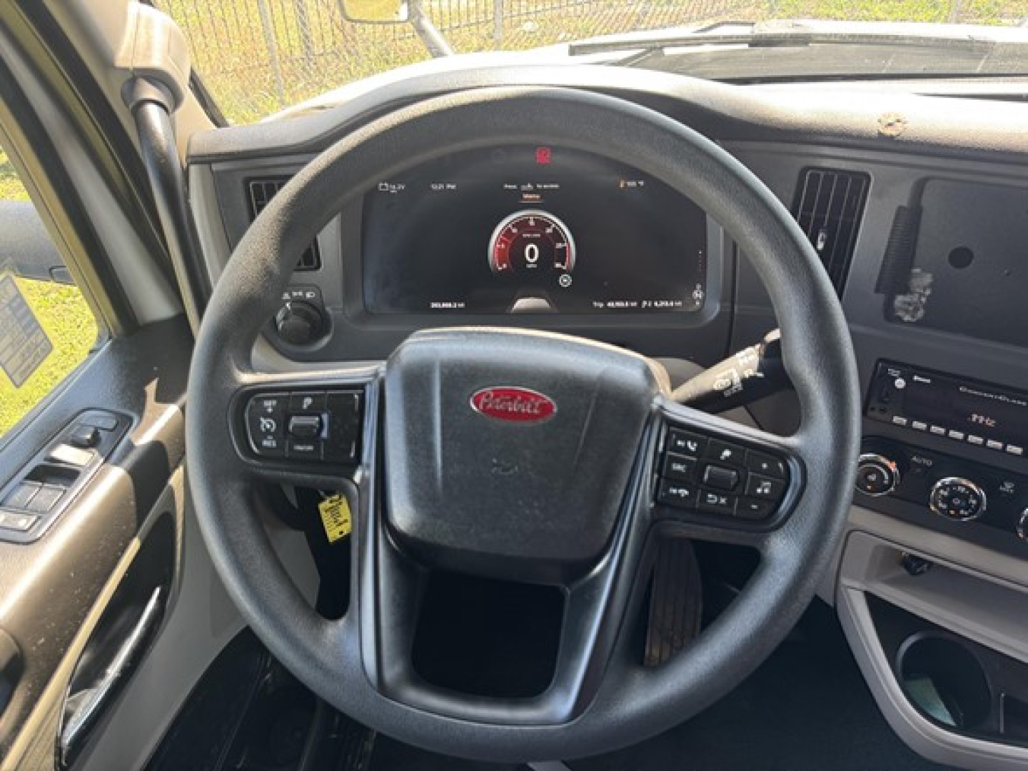 Peterbilt 579 steering wheel and dashboard view showing digital gauge cluster and controls.