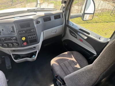 Interior of a 2024Peterbilt 579 truck cab showing dashboard controls, steering column, and front passenger seat.