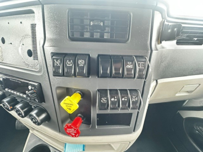 Peterbilt 579 dashboard with control switches and ignition keys area showing yellow and red switch handles.