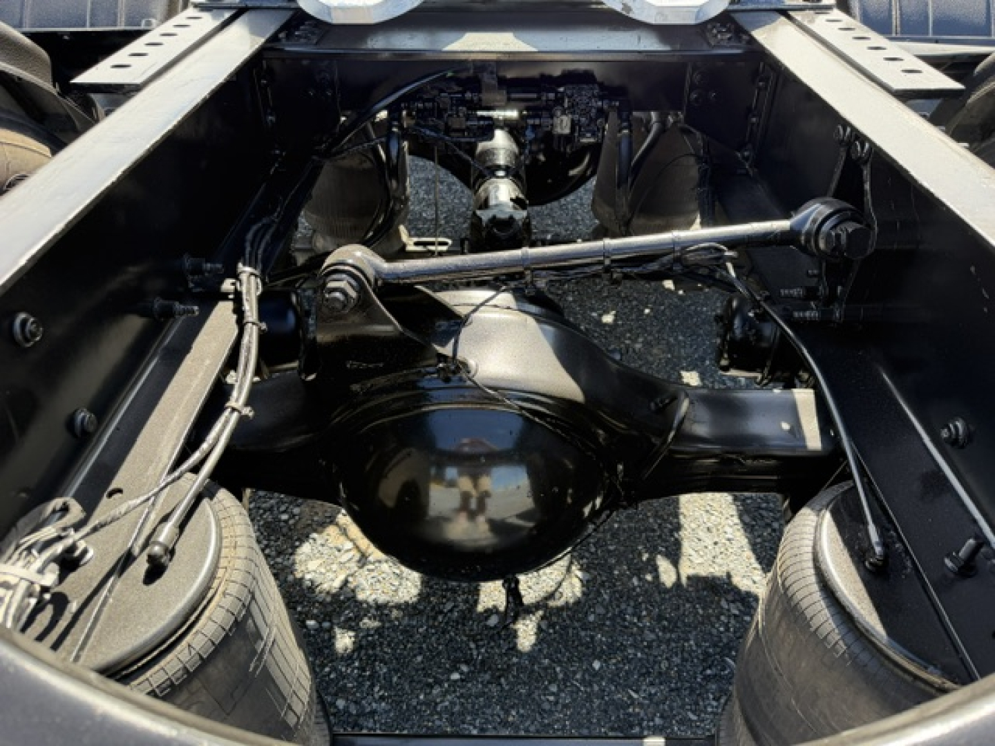 Volvo VNL64T300 chassis view showing rear axle, differential, leaf springs, driveshaft, and surrounding frame members.