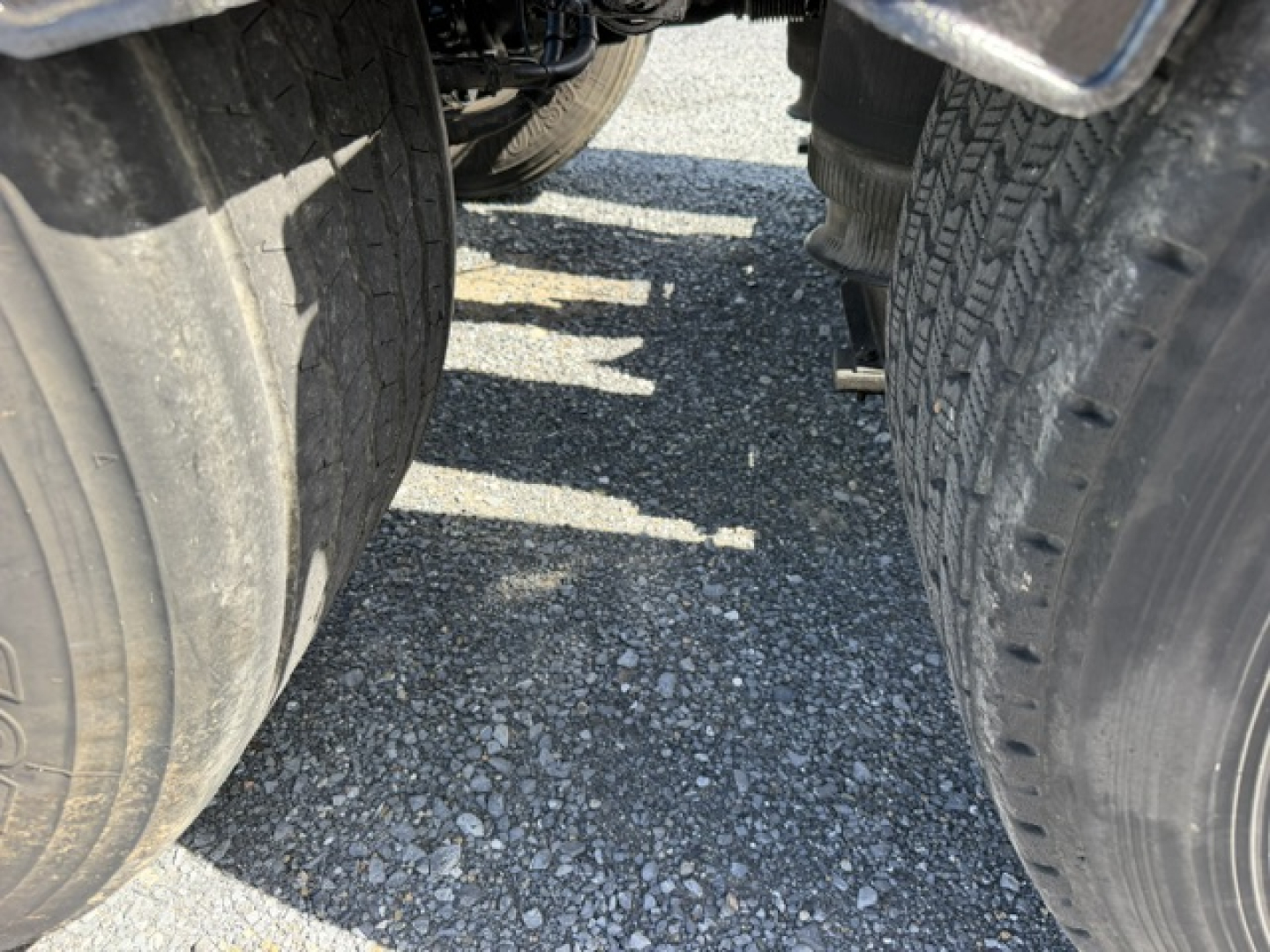 Wheel area of a 2016 Volvo VNL64T300 truck showing dual rear tires and undercarriage components.