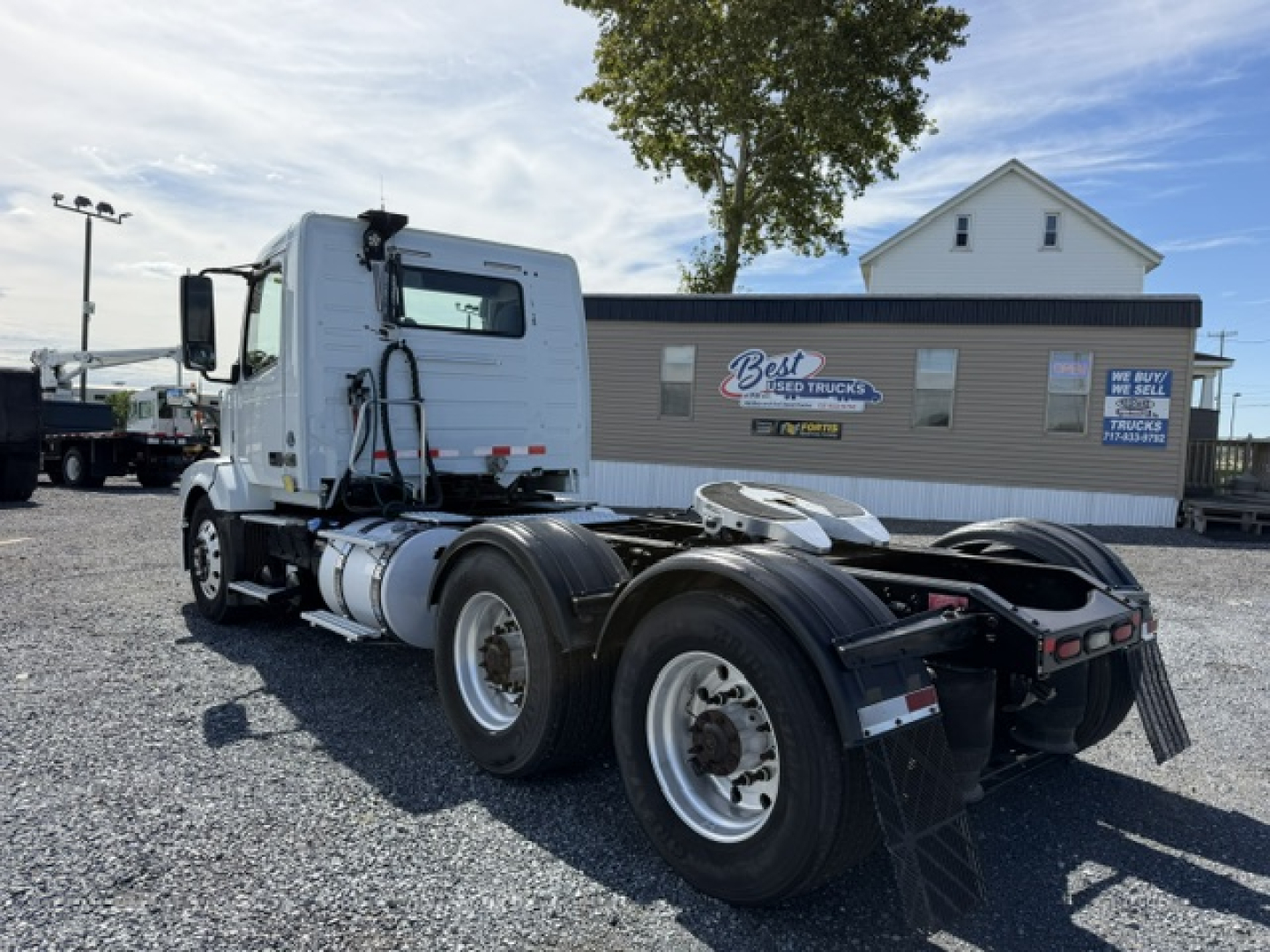 Truck chassis as viewed from rear-left showing Volvo VNL64T300 cab, dual rear axles, fuel tanks, and fifth-wheel area.