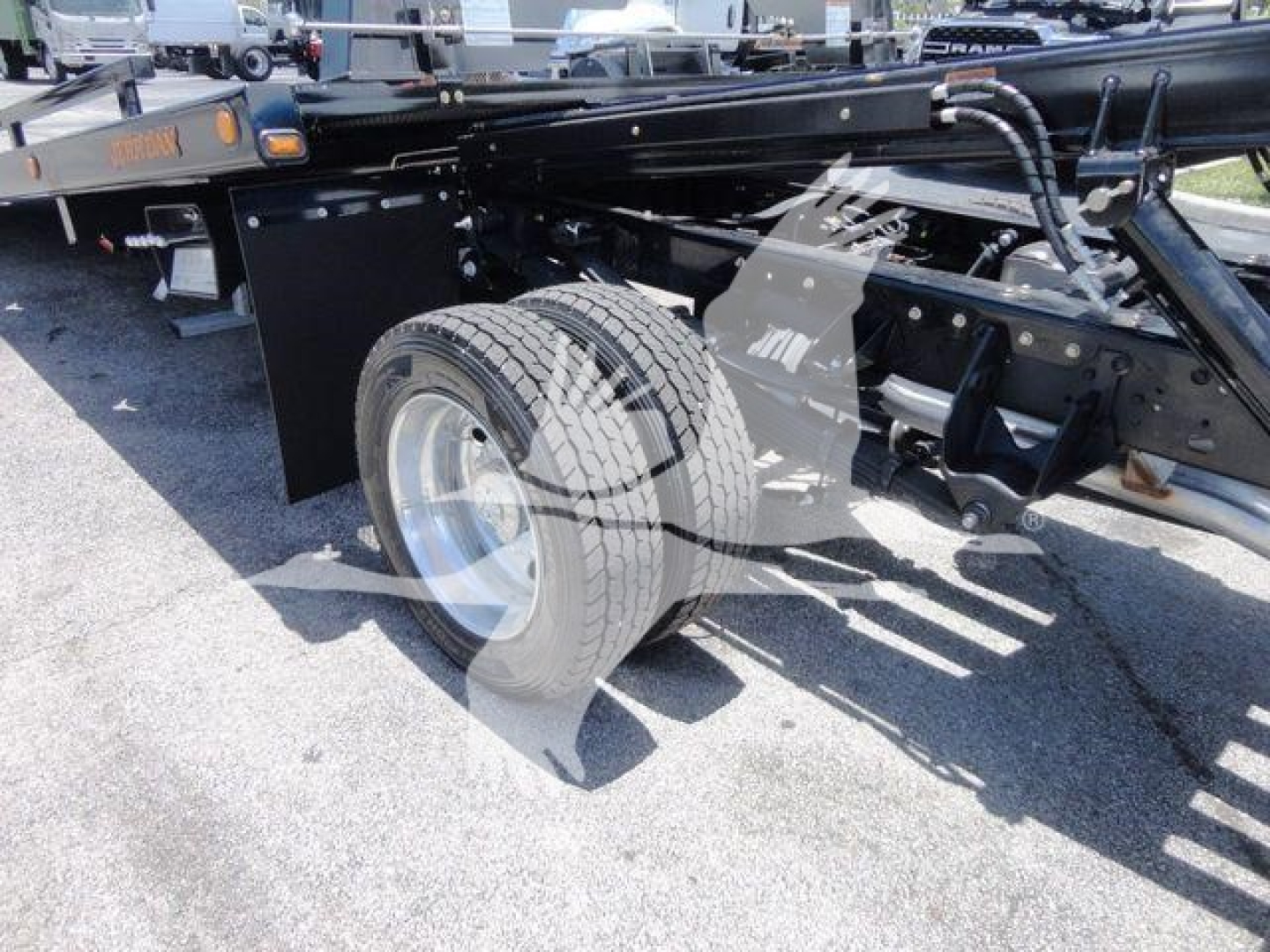 Ram 5500 chassis showing front wheel and suspension with rollback truck frame and components visible.