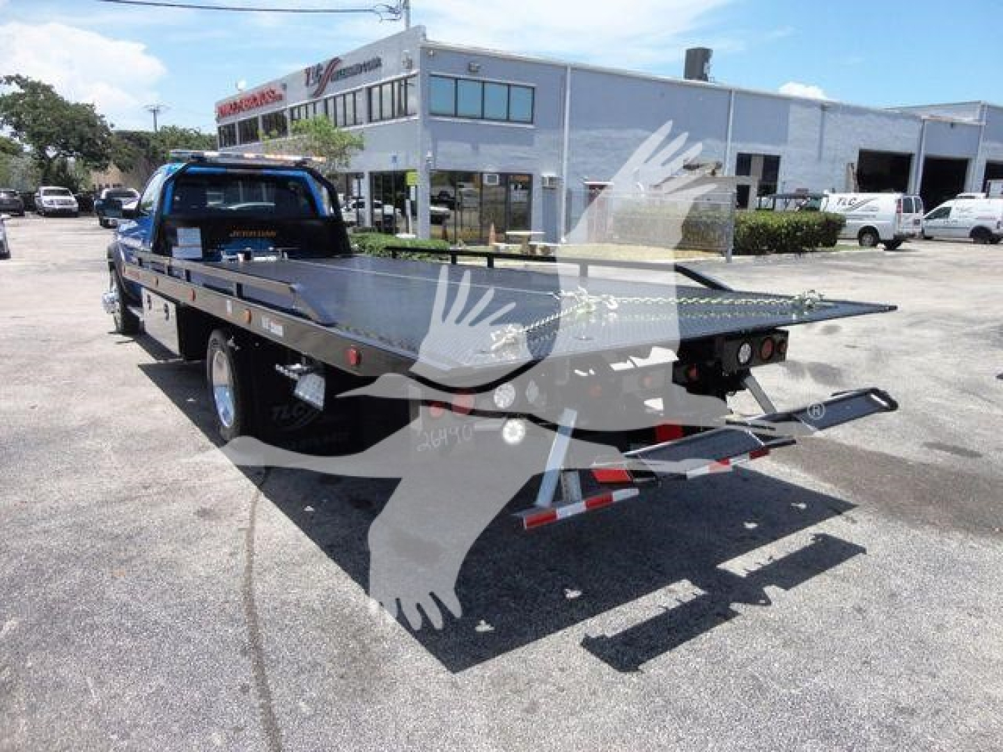 Ram 5500 rollback flatbed truck showing rear and flatbed with winch and dual rear lights.