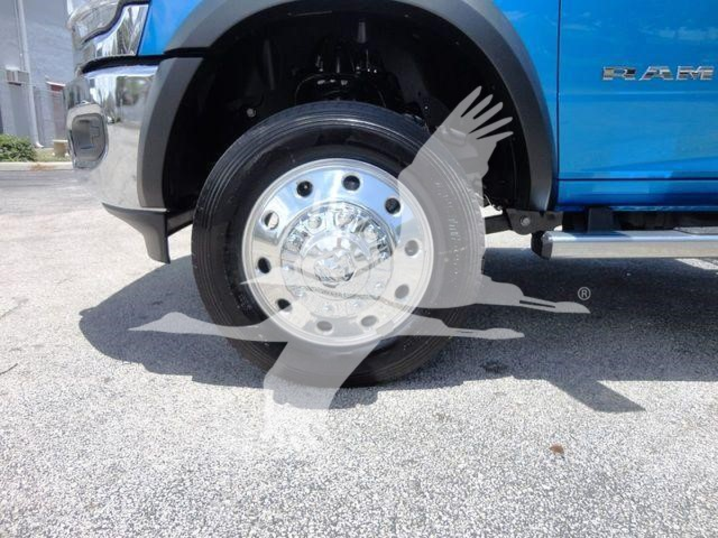 Ram 5500 SLT front wheel showing polished chrome hub and tire, blue body panel with RAM badge.