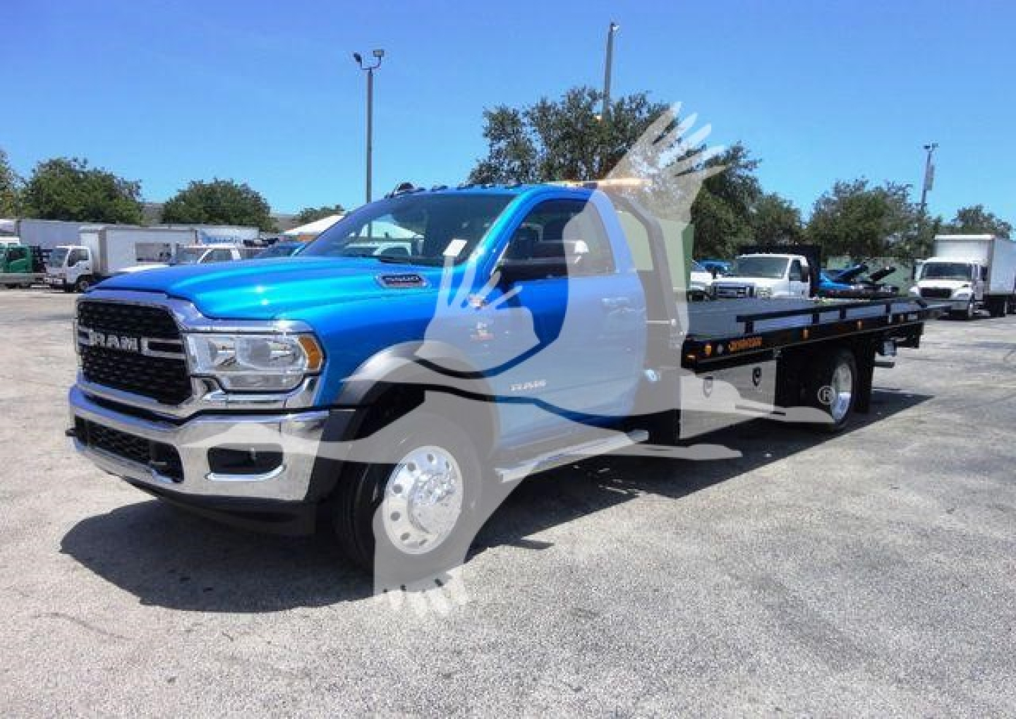 RAM 5500 SLT long-bed rollback tow truck in blue, front three-quarter view, chrome grille, dual rear wheels, wheel-lift bed.