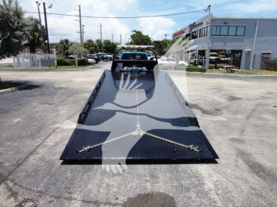 2024 Ram 5500 SLT listing image shows a rollback tow truck with a long black steel platform and ramps in the foreground.