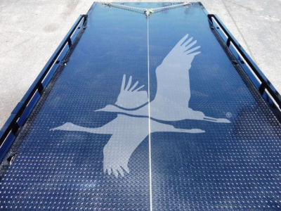 Truck bed with Diamond plate surface and a large white bird graphic in flight on the ramp.