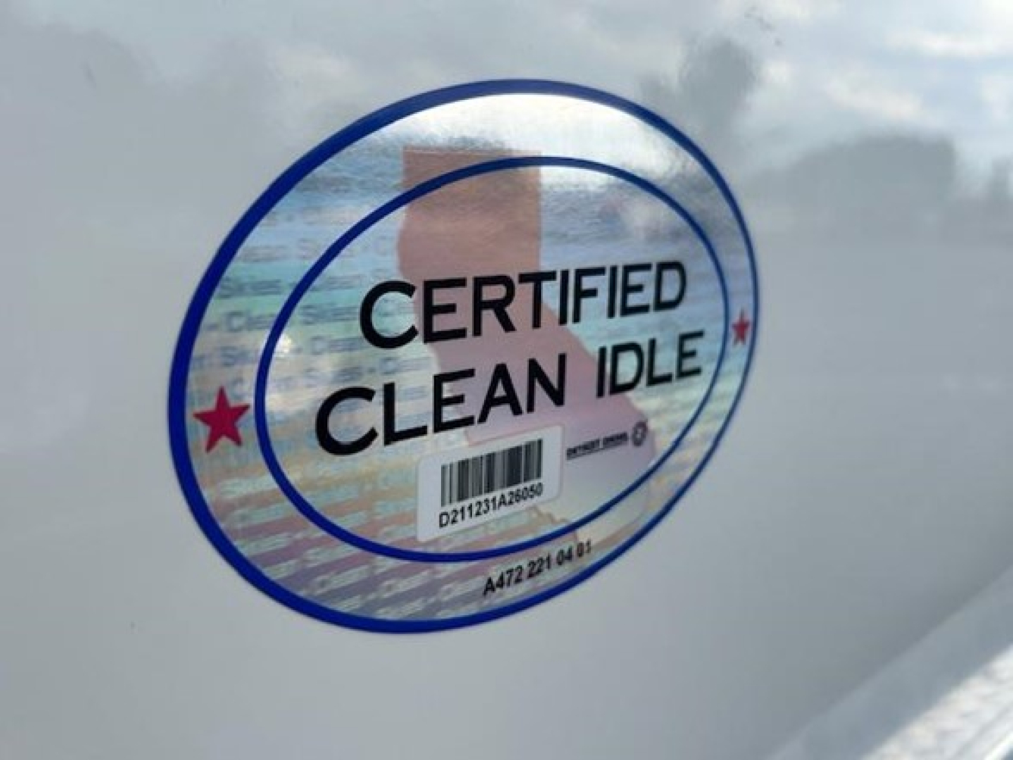 Sticker on glossy surface showing CERTIFIED CLEAN IDLE with circular blue border and red stars.