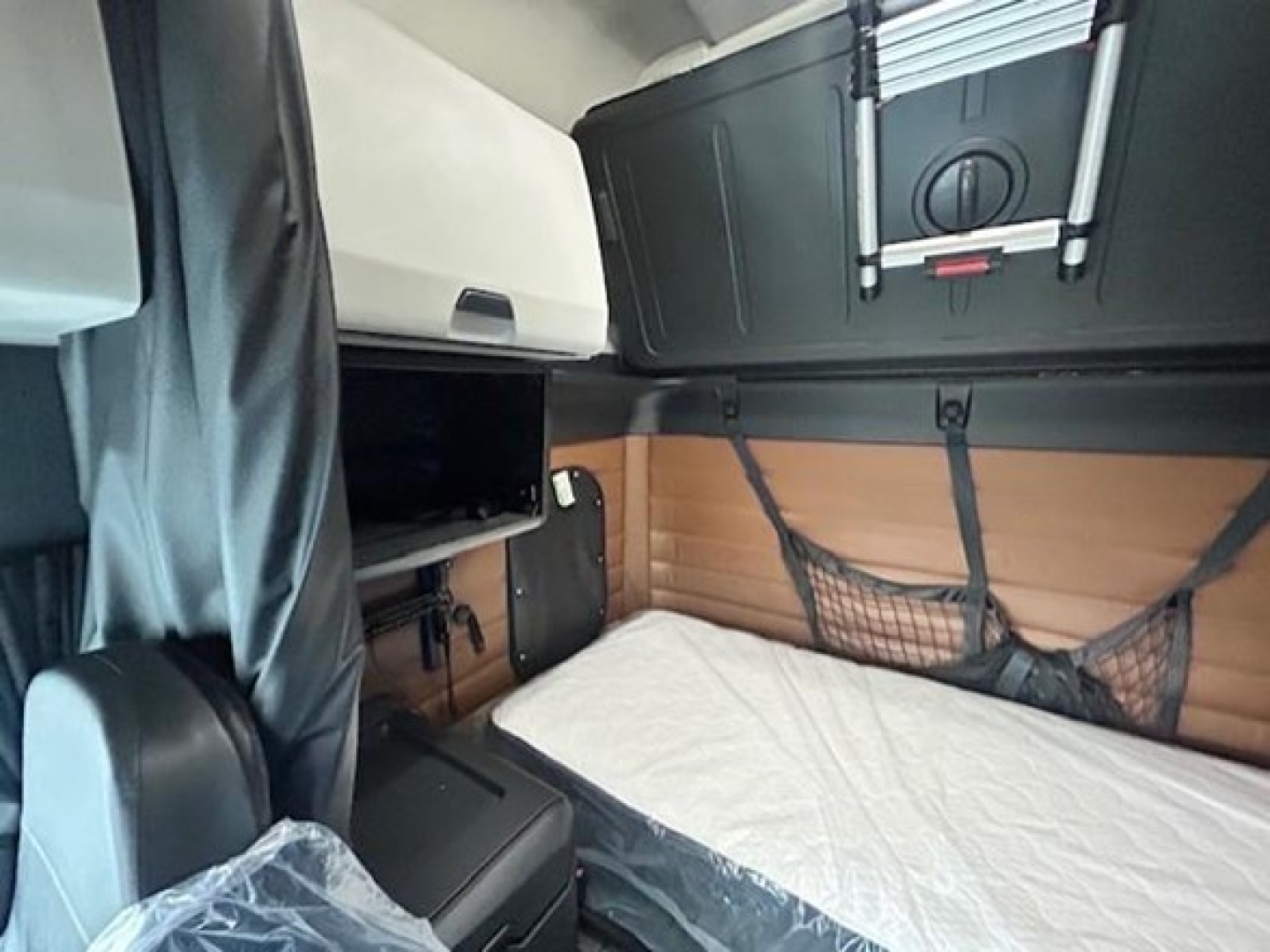 Truck cab interior showing sleeper berth area and storage compartments in a Freightliner Cascadia 126.