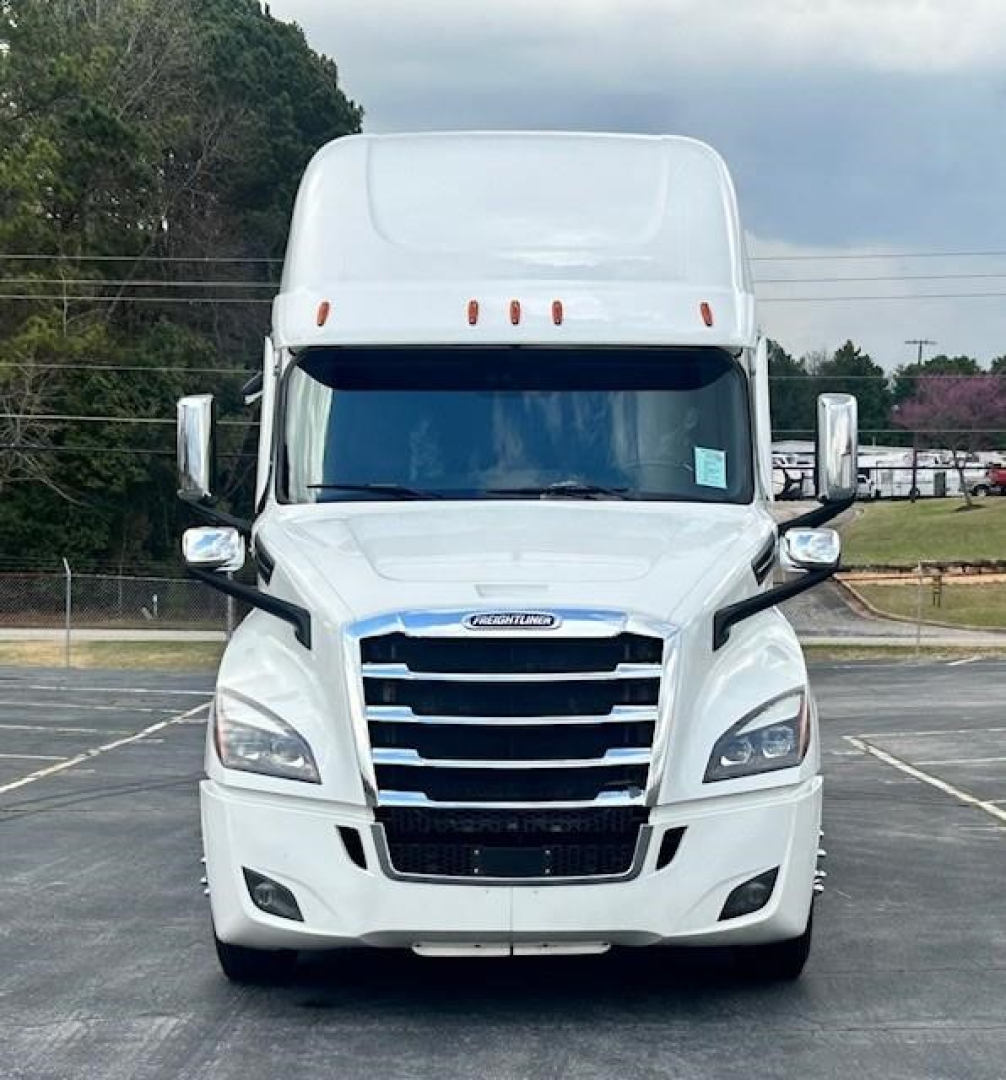 Front view of a white 2023 Freightliner Cascadia 126 sleeper tractor showing bold grille and headlights.