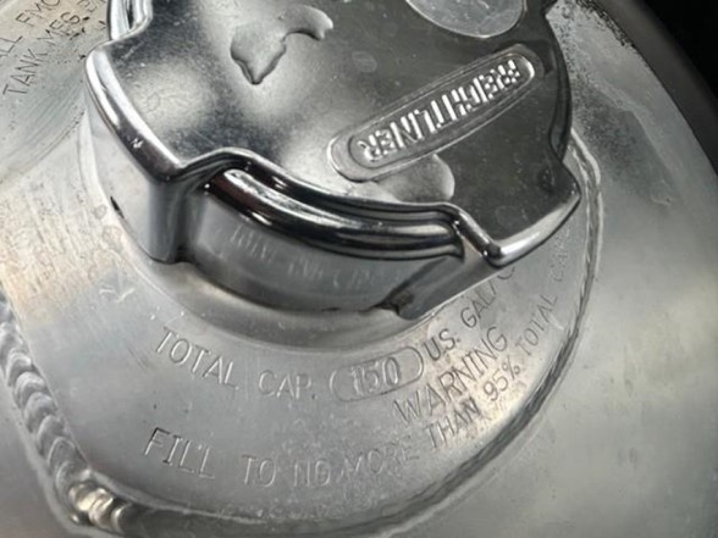 Fuel tank cap area of a Freightliner Cascadia 126 showing Gen 7? branding and fill instructions; visible text reads TOTAL CAP (150) GALLONS, WARNING TRAN 85%? and CAP LOCK.