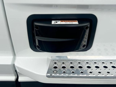Freightliner Cascadia 126 cab entry step and fuel fill port area with warning label visible.