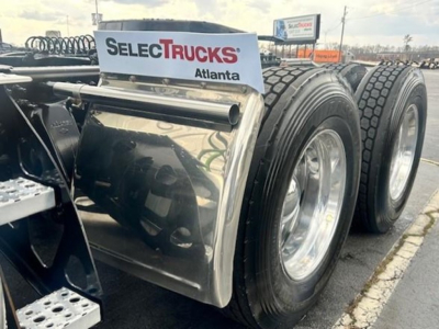 Truck rear view showing dual rear wheels and fuel tank on Freightliner Cascadia 126 sleeper cab chassis with SelecTrucks Atlanta sign.