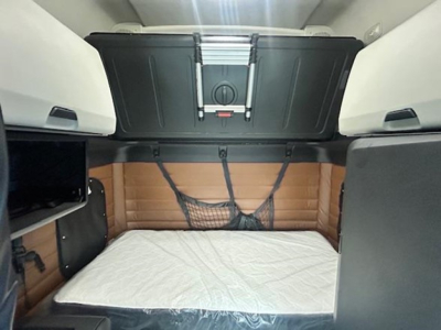 Freightliner Cascadia 126 sleeper cab interior showing bunk area with mattress and storage compartments.