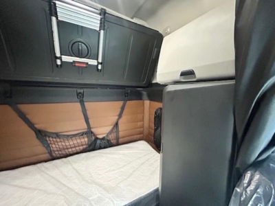 Freightliner Cascadia 126 sleeper cab interior showing bunk area with storage cabinet and netted pocket.