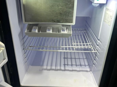 Fridge/freezer unit inside a truck cab showing empty shelves and drawers.