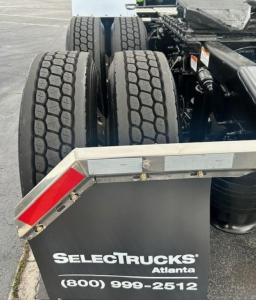 Truck rear with dual tires and SelectTrucks Atlanta plate showing wheel configuration and bumper reflector.