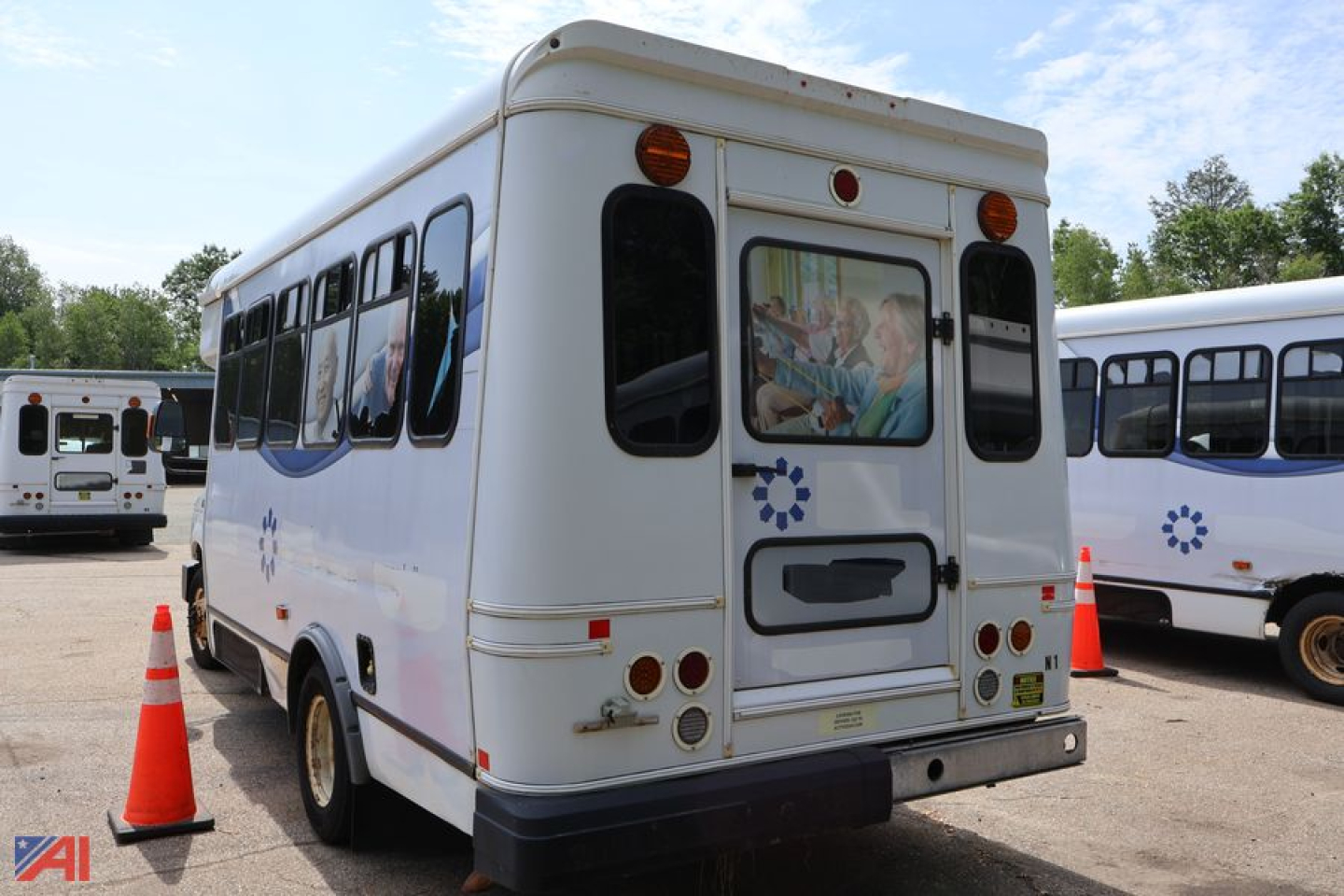 Ford E350 (N-1) wheelchair bus rear view showing back doors and windows, with other buses in background.