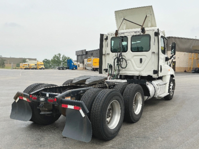 Freightliner Cascadia125 truck tractor rear view showing dual rear axles and fifth wheel area with mud flaps.