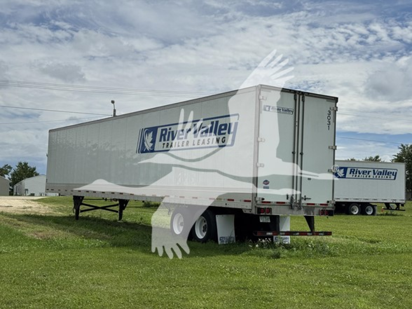 Utility trailer 4000D-X with River Valley Trailer Leasing logo on side, side view showing rear doors, in a grassy lot.