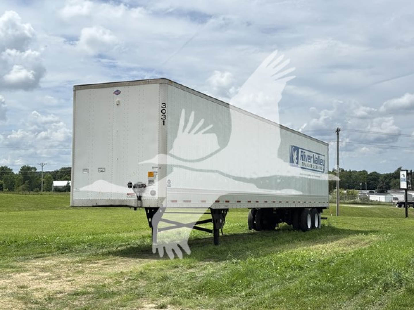 Utility trailer 2023 model 4000D-X with RiverValley Transportation logo shown in a grassy lot.
