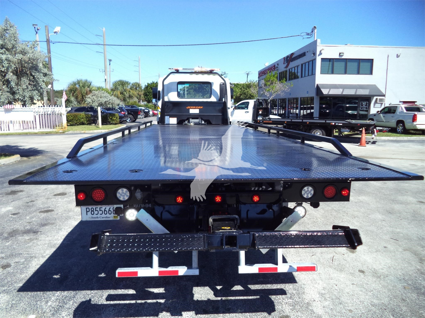 Isuzu FTR rollback bed of tow truck viewed from rear with platform extended.