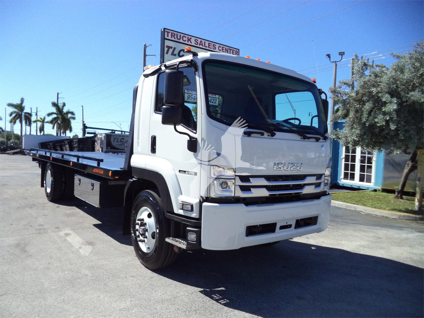 Isuzu FTR rollback truck in side view showing flatbed and cab with Isuzu emblem on grille