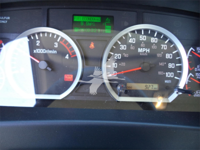 Dashboard view of a 2025 Isuzu FTR rollback truck showing speedometer, tachometer, and center digital display with green status readouts.