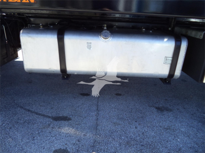 Isuzu FTR rollback truck fuel tank and undercarriage with two side straps and a central cap, visible on a paved surface.