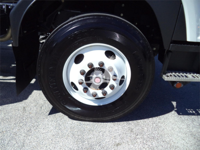 Isuzu FTR wheel and tire close-up showing steel wheel with lug nuts and hub, part of rollback truck.