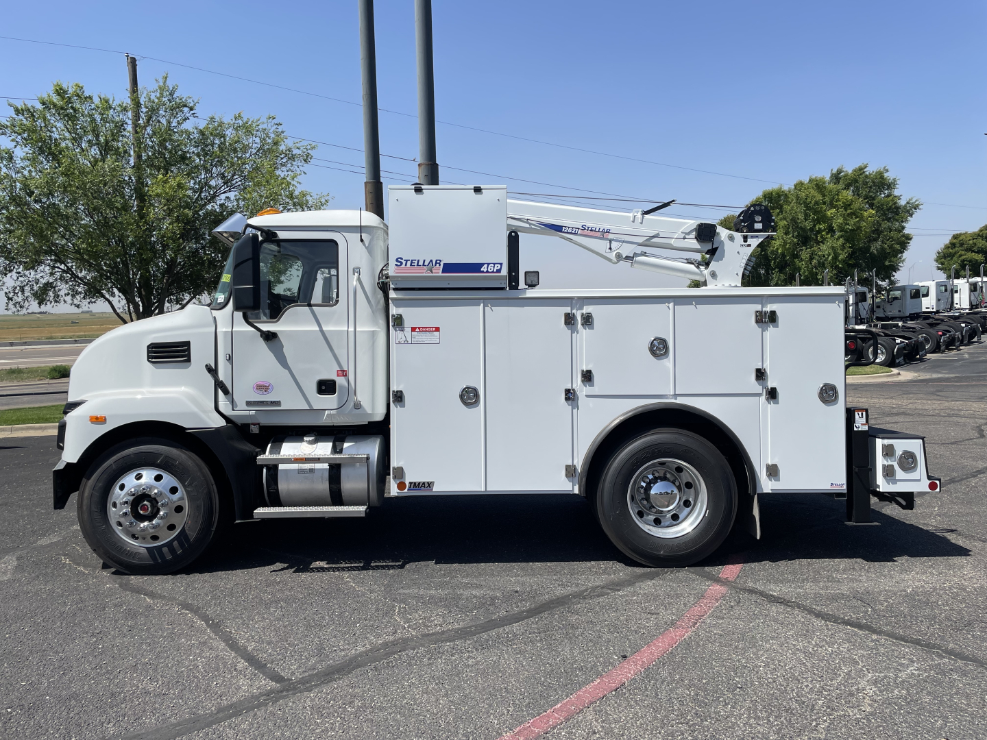 Truck body side showing service utility truck with crane boom labeled 'Stellar' on white cab and utility compartments.