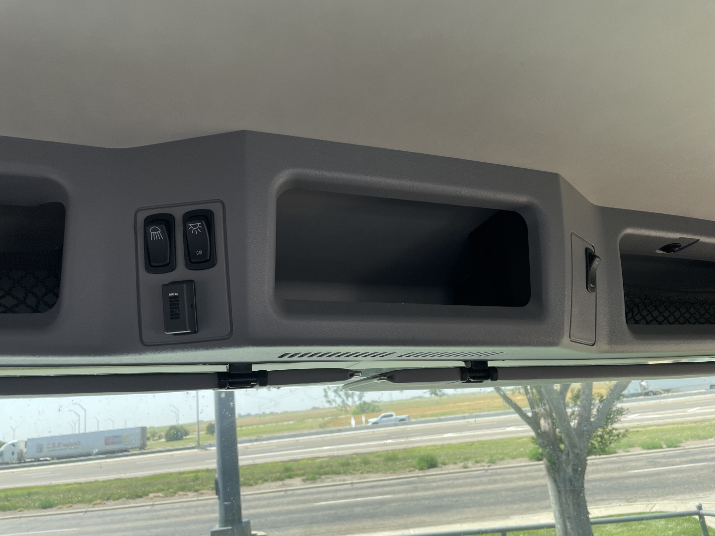 Cab overhead area showing storage compartments and switches in a Mack MD6 truck interior view.