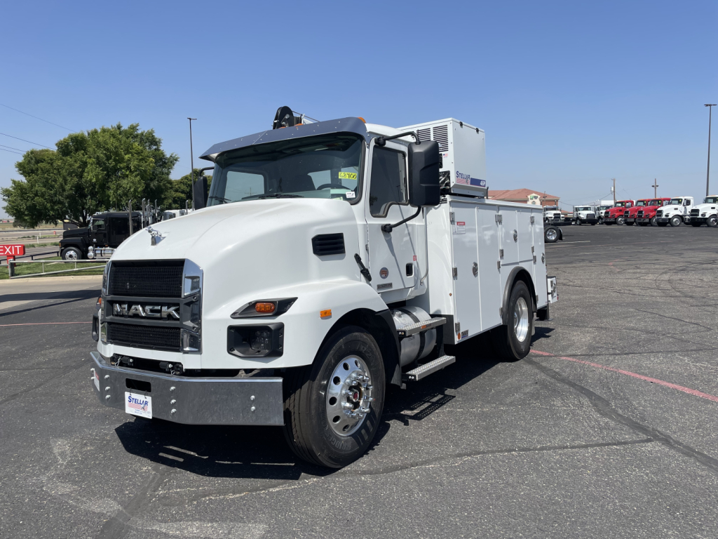 White Mack MD6 service truck in a parking lot, showing front and left side with utility compartments and a crane on top.