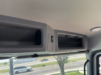 Mack MD6 cab interior showing overhead storage compartments and sun visor area.