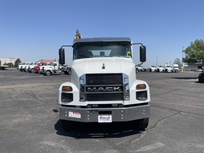 Front view of a white 2026 Mack MD6 service truck showing MACk grille, bumper, and headlights. visible stickers on bumper and windshield.