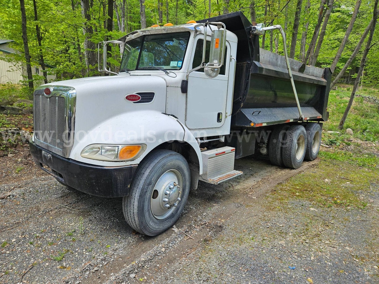 Peterbilt 335 dump truck in-service showing front and right-side view with dump bed and dual rear wheels.